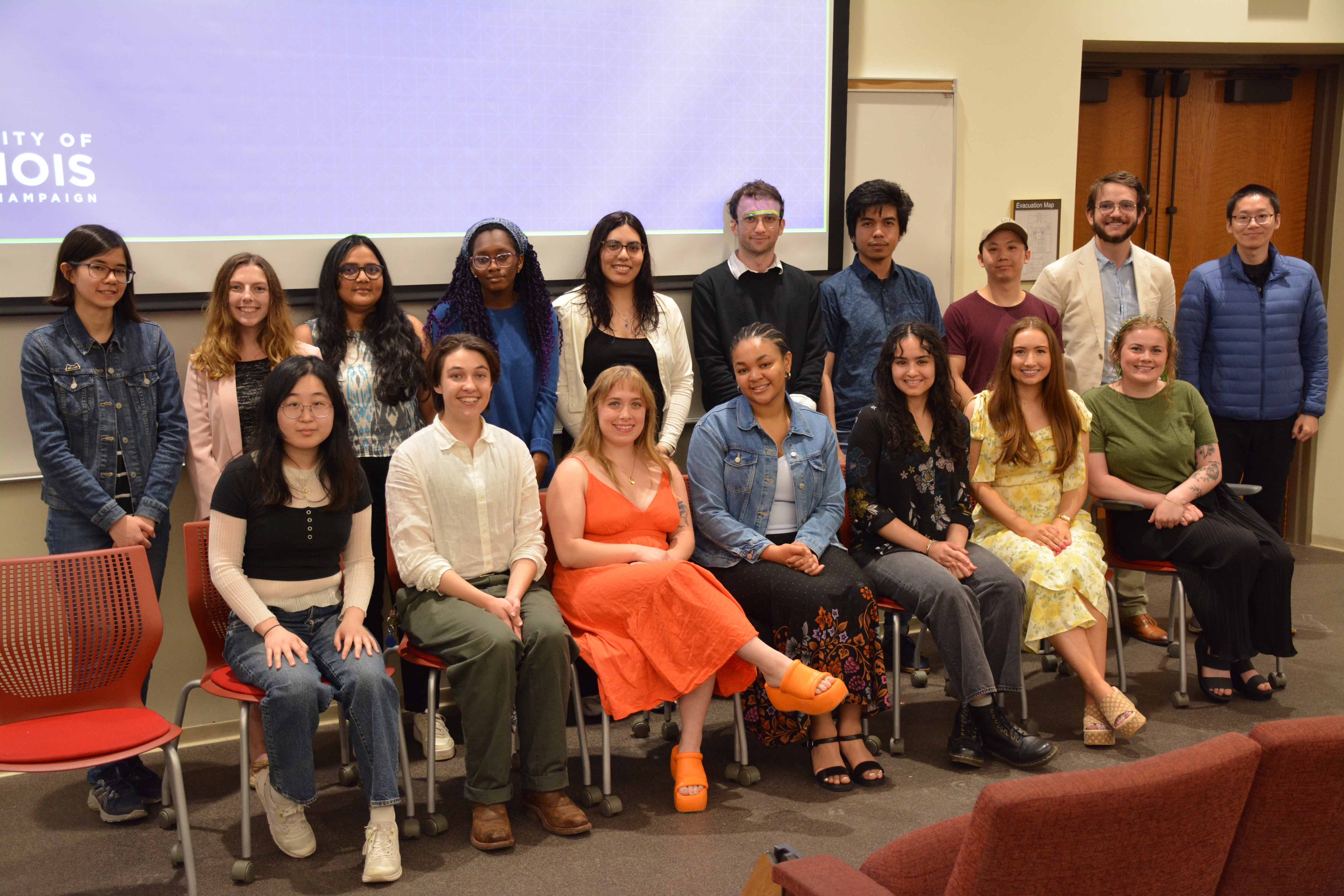 a group of students sitting and standing at the front of an auditorium