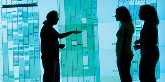 a man talking to women in front of data