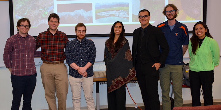 A group of people standing together and smiling for a camera