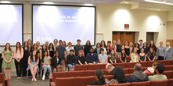 auditorium with undergraduate award winners lined up in the front for a photo