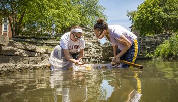 student and instructor seine fishing on campus