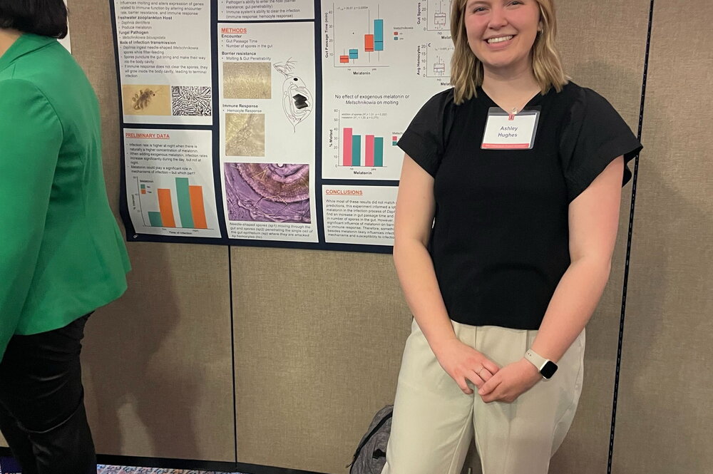 A woman standing next to a poster