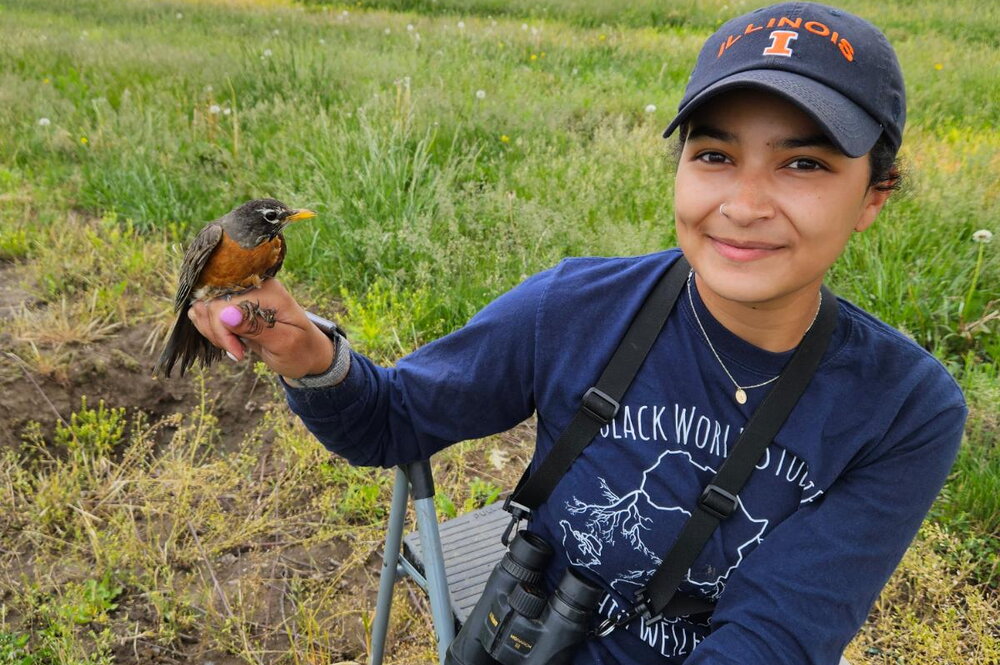 Abbigail Turner holding a bird in a field