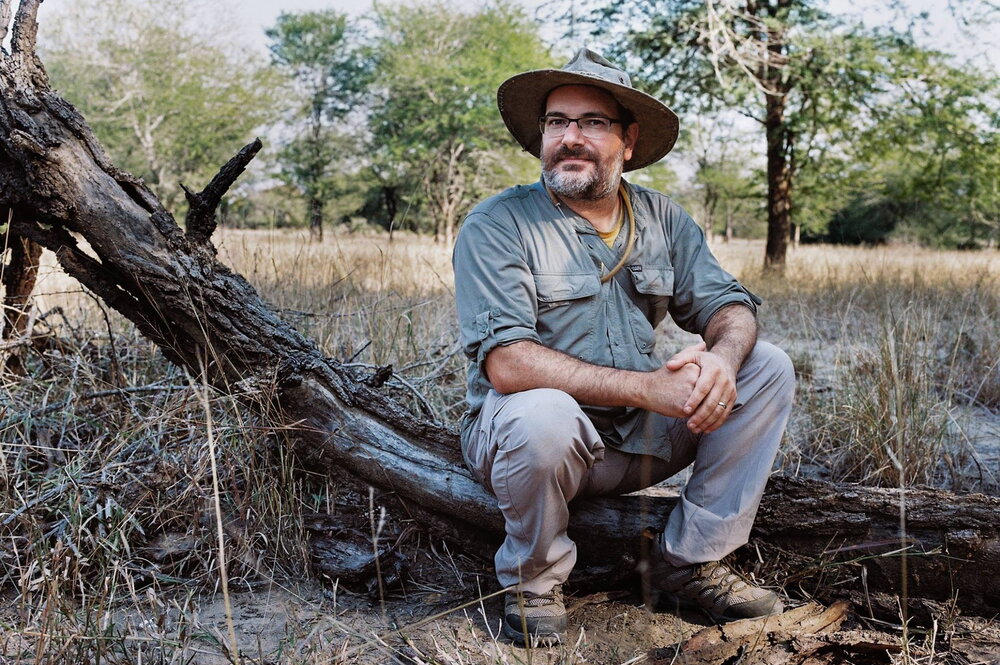 Andy Suarez sitting on a fallen tree 