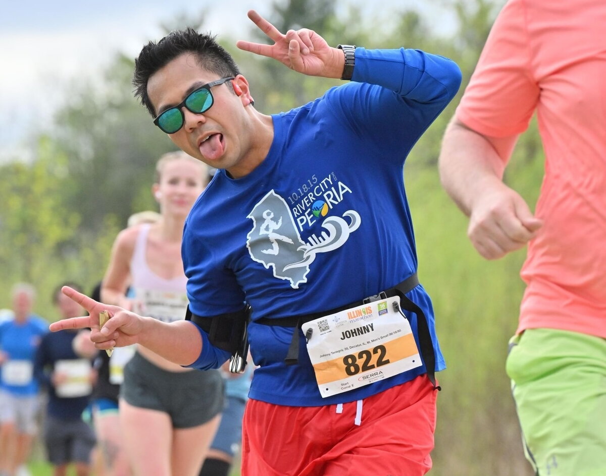 A man running in a marathon giving a goofy pose
