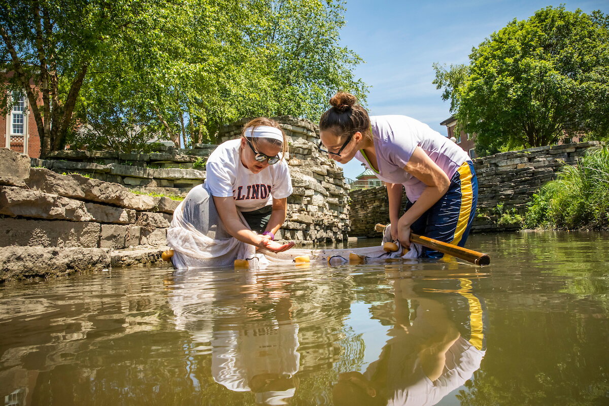two women catching fish in a stream