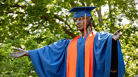 Alma Mater wearing a Illini blue graduation robe.