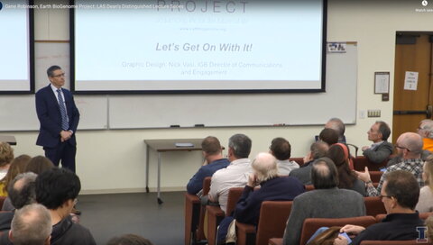 man in suit speaking at a lecture