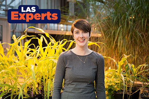 smiling person in front of plants