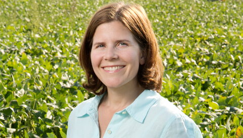 smiling person in front of plants