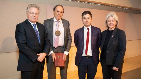 four people commemorating an award