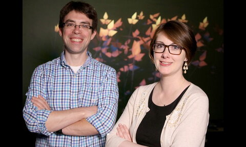 two smiling people with arms crossed