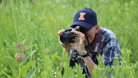 happy man taking a photo in a field