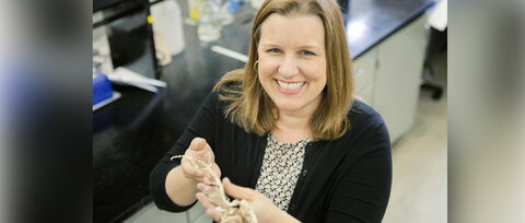 woman holding a small animal skeleton