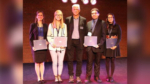 five people commemorating an award