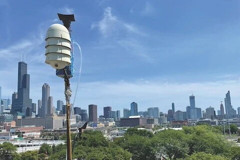 A device on a pole with the skyline of Chicago in the background