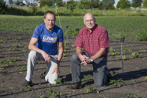 two men kneeling in a field