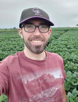 A headshot of Jeff Hansen standing in front of a field