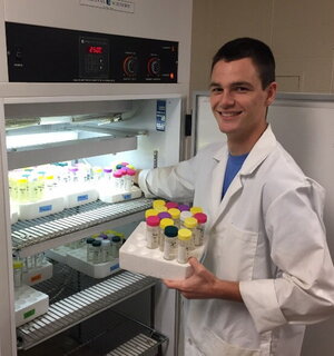 a man in a lab coat holding test tubes