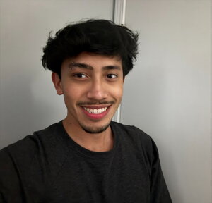 A man in a black shirt smiling