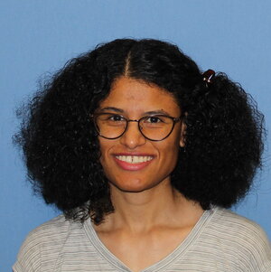 A smiling woman in a grey shirt