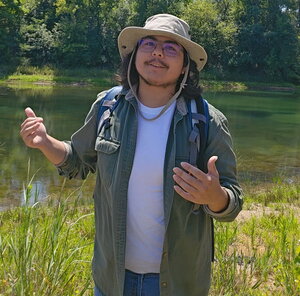 A man holding up his hands in a wetlands area
