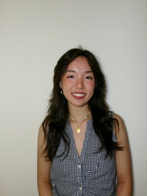 A smiling brunette woman in a checkered shirt