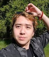 A person holding their hand over their head outside