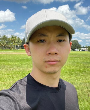 A man in a tan hat and black shirt standing outside