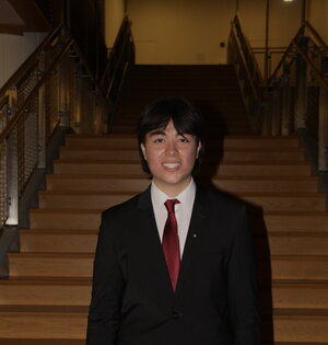 A man in a suit standing in front of a flight of stairs