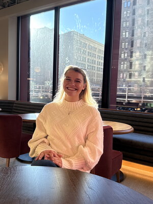 A smiling woman in a building with Chicago in the background
