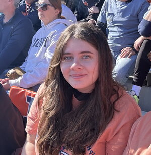 A brunette woman in orange at a sporting event