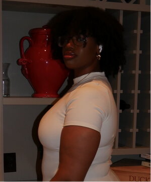 a woman in a white shirt standing in front of a bookshelf