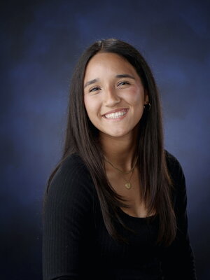 A smiling brunette woman in a sweater