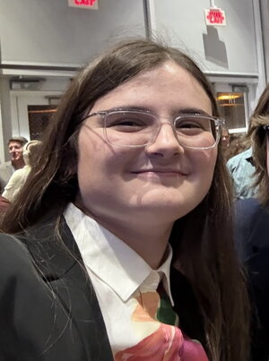 a woman in glasses smiling