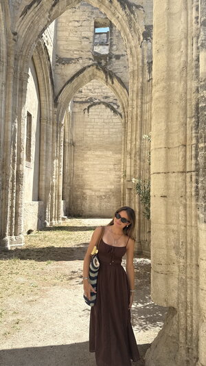 girl standing in historical outdoor hallway