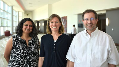 Two women and a man smiling for a photo