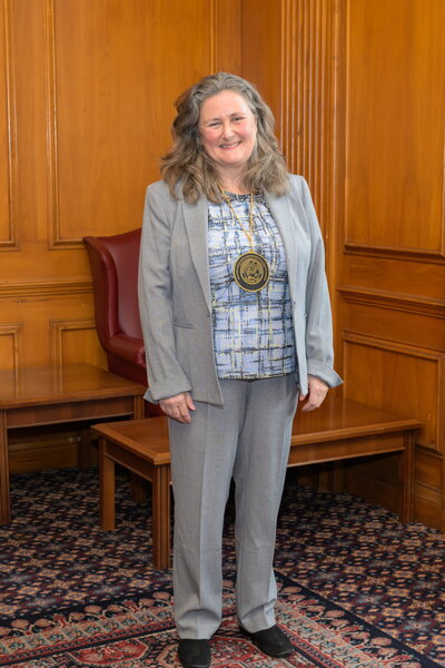 A smiling woman wearing a medallion