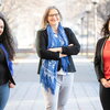 three smiling people at a walking path