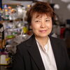 smiling person in front of a lab shelf