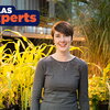 smiling person in front of plants