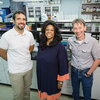 three smiling people in a lab