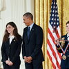 woman receiving medal from Obama