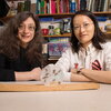 photo of two women and a ball with bees inside