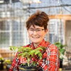 Erinn in greenhouse holding plant in pot