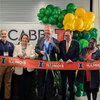 A group of individuals cutting a giant ribbon