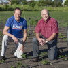 two men kneeling in a field