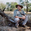 Andy Suarez sitting on a fallen tree 