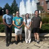 students posing next to one another in front of a fountain