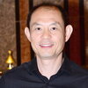 a man smiling in a blue button down shirt